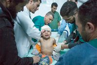 2011, Libya. A child wounded in a rocket attack is treated by medics in a makeshift hospital